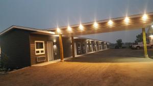 a gas station with a garage with lights on it at Centennial Motel in Kindersley