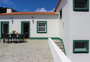a white and green house with a table and chairs at Casa da Altamora - up to 12 guests! in Cais do Galego