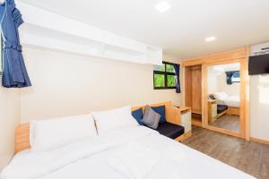 een slaapkamer met een groot wit bed en een kamer bij Memory Karon Resort in Karon Beach