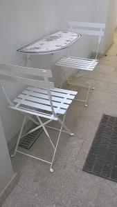 2 sillas blancas y una mesa en una habitación en Loft Mártires, en Oporto