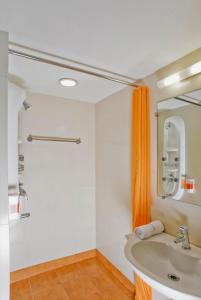 a bathroom with a sink and an orange shower curtain at Ginger Ahmedabad Vastrapur in Ahmedabad