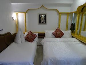 En eller flere senge i et værelse på Aloha Hotel