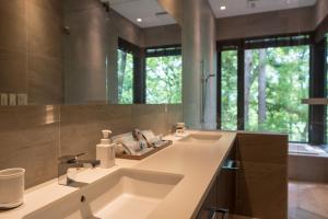 a bathroom with two sinks and a large mirror at Villa El Cielo Hakuba in Hakuba
