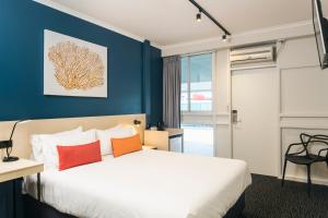 a hotel room with a large bed and a large window at Nightcap at Edge Hill Tavern in Cairns