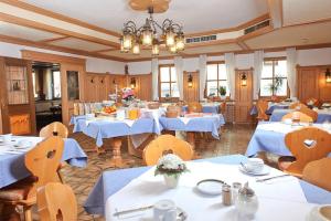 a restaurant with blue tables and chairs and a chandelier at Bayerischer Hof in Ingolstadt