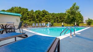 a large swimming pool with chairs and a table and a tablektop at Best Western Plus South Hill Inn in South Hill