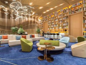 a library with chairs and tables and bookshelves at NOVOTEL Jinji Lake Suzhou SIP in Suzhou