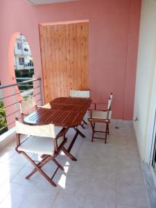 d'une table et de chaises en bois sur un balcon. dans l'établissement Rafina Port Paradise, à Rafína