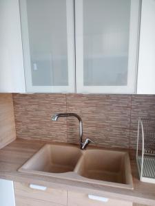a kitchen sink with a faucet and two windows at Rafina Port Paradise in Rafina