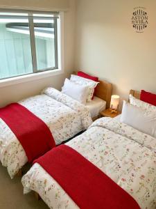 two beds sitting next to each other in a bedroom at Aston Road Villa Bed & Breakfast in Waikanae