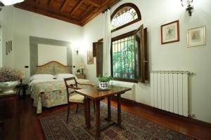 a bedroom with a bed and a table and a window at Casa Del Vescovo in Florence
