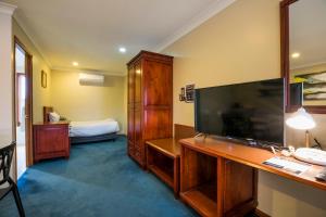 a bedroom with a television and a bed at Nightcap at Federal Hotel Toowoomba in Toowoomba