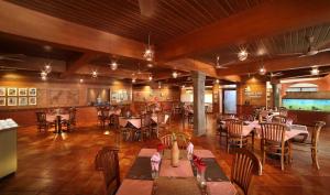 un restaurante con mesas y sillas en una habitación en Uday Suites - The Airport Hotel, en Trivandrum