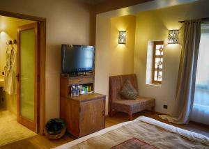 een slaapkamer met een televisie en een stoel in een kamer bij 1st Gate Home- Fusion in Jaisalmer