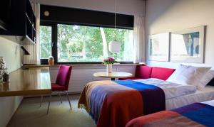 a bedroom with a bed and a table and a window at Kysthotellet in Grenå +53 photos