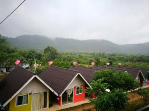 un grupo de casas con pingoles en sus tejados en Baan Rai Pray Rung Kaeng Krachan, en Ban Tha Ling Lom