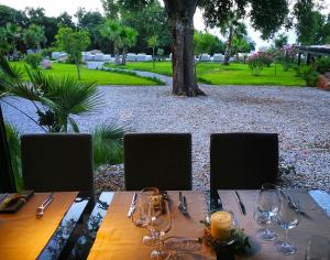 a wooden table with wine glasses on top of it at Vallegrande Nature Resort by Geocharme in Cefalù