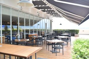 太平太平诺富特酒店的一家有桌椅和窗户的餐厅