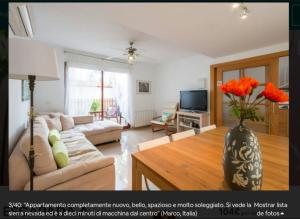 sala de estar con sofá y jarrón con flores en Casa Escapada a Granada, en Armilla