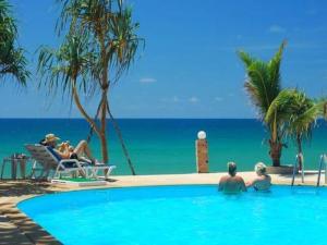 a group of people in a swimming pool near the ocean at Lanta Nice Beach Resort - SHA Extra Plus in Ko Lanta