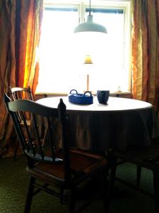 una mesa con una lámpara y una silla frente a una ventana en Boda, en Boda