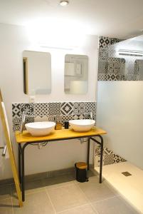 a bathroom with two sinks and a mirror at L'Estampe in Montagne