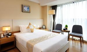 Postel nebo postele na pokoji v ubytování Yuwa Serviced Residence