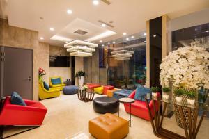 a lobby with colorful chairs and a glass table at Aaron Hotel in Nha Trang