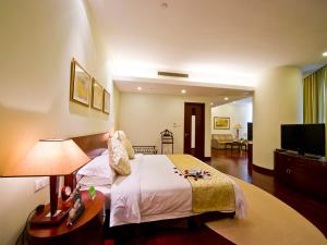 ein Hotelzimmer mit einem Bett und einem TV in der Unterkunft Ramada Plaza Sino-Bay Shanghai in Fengxian