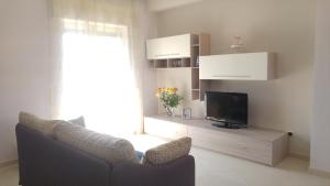 sala de estar con sofá y TV en Guest House " Chilli & Chocolate", en Pompeya