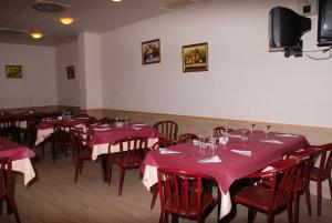 a dining room with red tables and chairs and a tv at Hostal Restaurante Baraka in Alagón