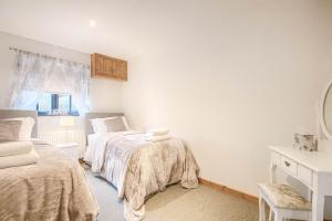 a bedroom with two beds and a mirror at Highgate Annexe in Takeley