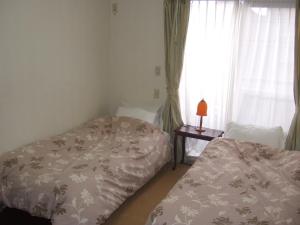 1 Schlafzimmer mit 2 Betten und einem Fenster in der Unterkunft tomy&tetu in Kyoto