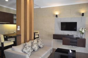 a living room with a couch and a flat screen tv at Puri Bintang in Nusa Dua