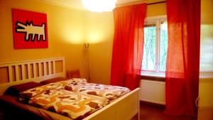 een slaapkamer met een bed en een raam met rode gordijnen bij Boda in Boda