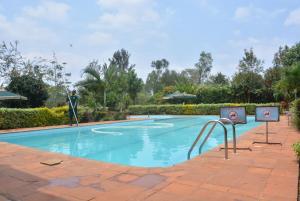 a swimming pool at a resort with a person playing at Bubbles Restaurant Thika in Thika