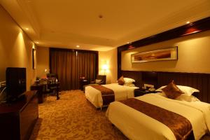 a hotel room with two beds and a desk at Ramada Changzhou in Changzhou