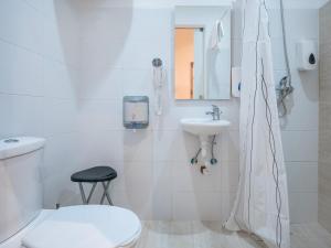 a white bathroom with a toilet and a sink at Valletta Kampnar City Living in Valletta