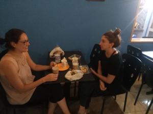 dos mujeres sentadas en una mesa comiendo comida en Nutz Backpackers en Amritsar