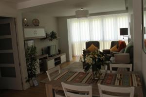 - un salon avec une table et des fleurs dans l'établissement Apartamento Datue, à Elizondo