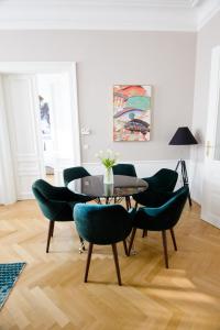 une salle à manger avec une table et des chaises vertes dans l'établissement Studio Apartments Urania - Mai's Apartments by Arbio, à Vienne
