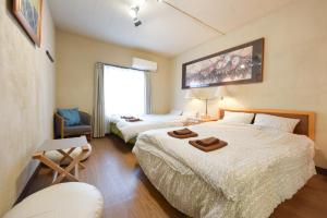 una habitación de hotel con 2 camas y una silla en Yoyogi House, en Tokio