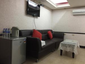 uma sala de estar com um sofá e uma televisão em King Lo Tung Hotel em Luodong