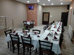 a long table with white tables and chairs in a room at Hotel Tranzit in Odorheiu Secuiesc