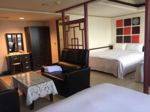 une chambre d'hôtel avec un lit, une chaise et une table dans l'établissement King Lo Tung Hotel, à Luodong
