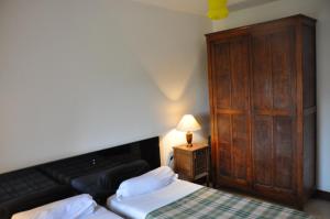 1 dormitorio con 1 cama y armario de madera en Maison vedrines saint loup cantal, en Montchamp