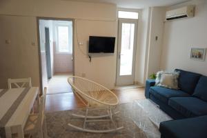 Apartment Corto في بولا: غرفة معيشة مع أريكة زرقاء وطاولة