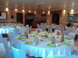 a room with white tables and chairs with white table cloth at Hotel Restaurant Denis in Zemmer