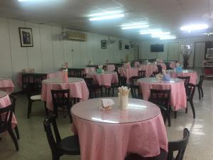 een kamer gevuld met tafels en stoelen met roze tafelkleed bij King Lo Tung Hotel in Luodong