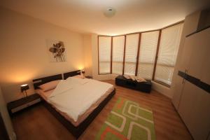 a bedroom with a bed and two windows at Cozy Apartment Next to Gondola in Bansko
